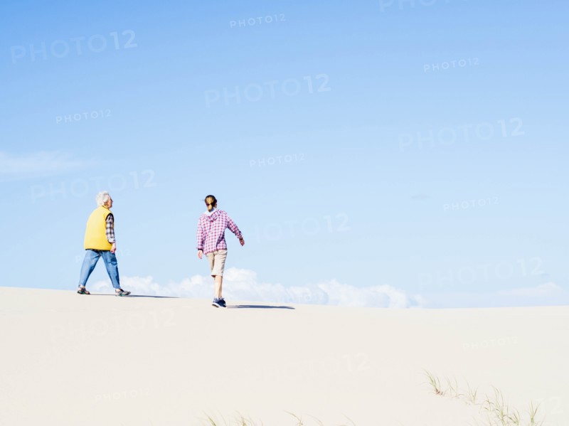 Mother and daughter walking on sand dune in Hawke's Nest, New South Wales, Australia