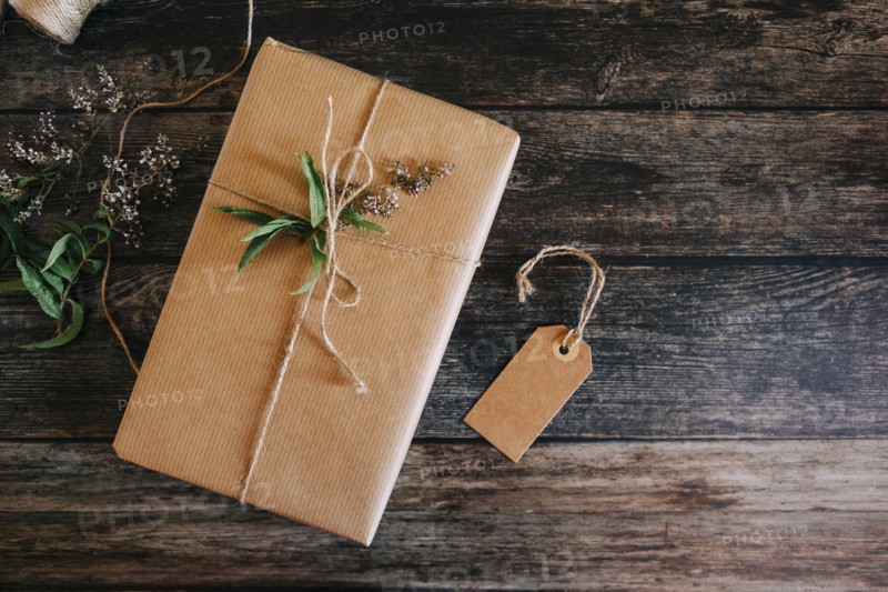 Present wrapped in brown paper and string with label and flowers