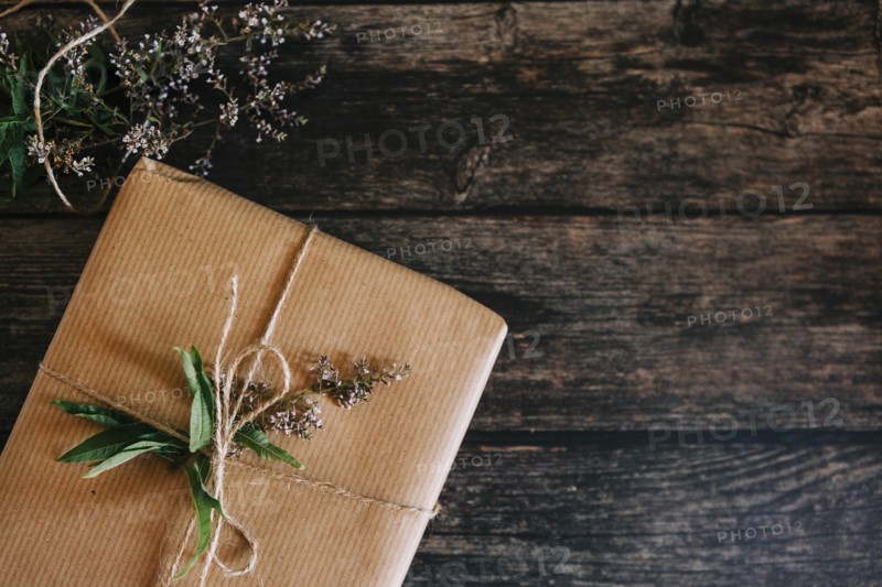 Present wrapped in brown paper with string and flowers