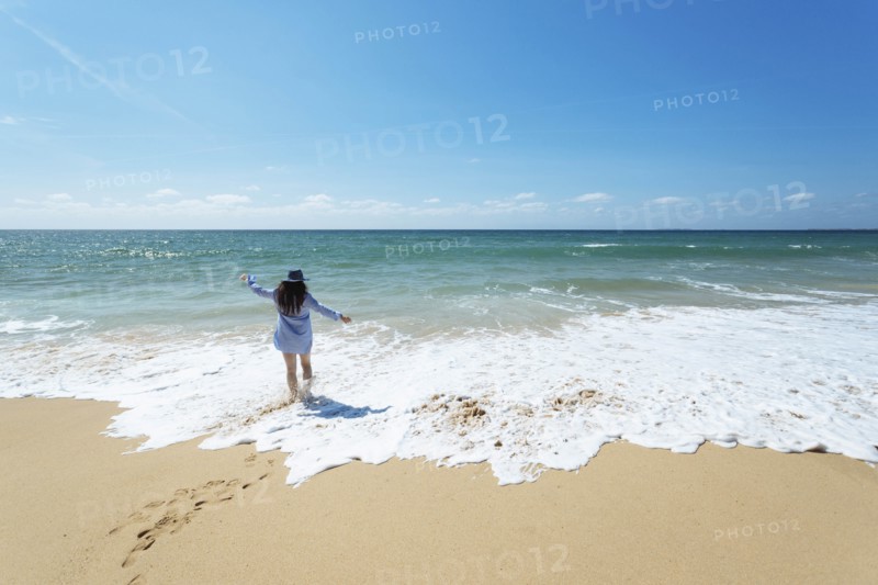 Woman walking on beach in Lisbon, Portugal