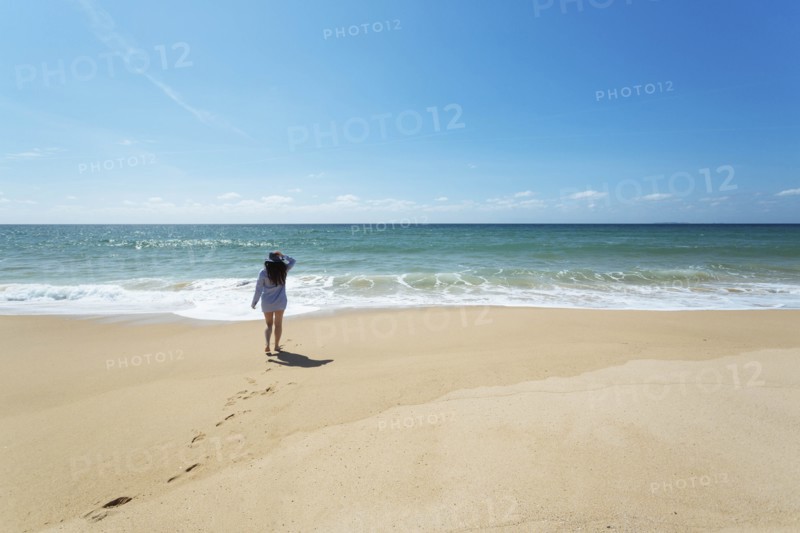 Woman walking on beach in Lisbon, Portugal