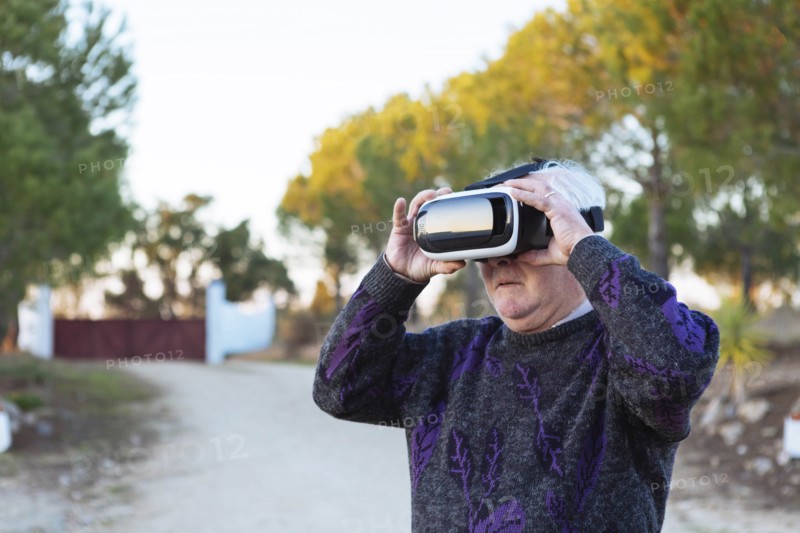 Senior man wearing virtual reality simulator outdoors