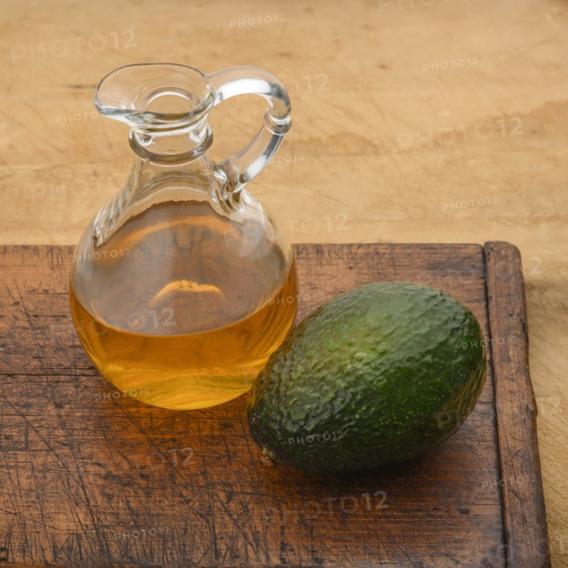 Avocado with pitcher of oil