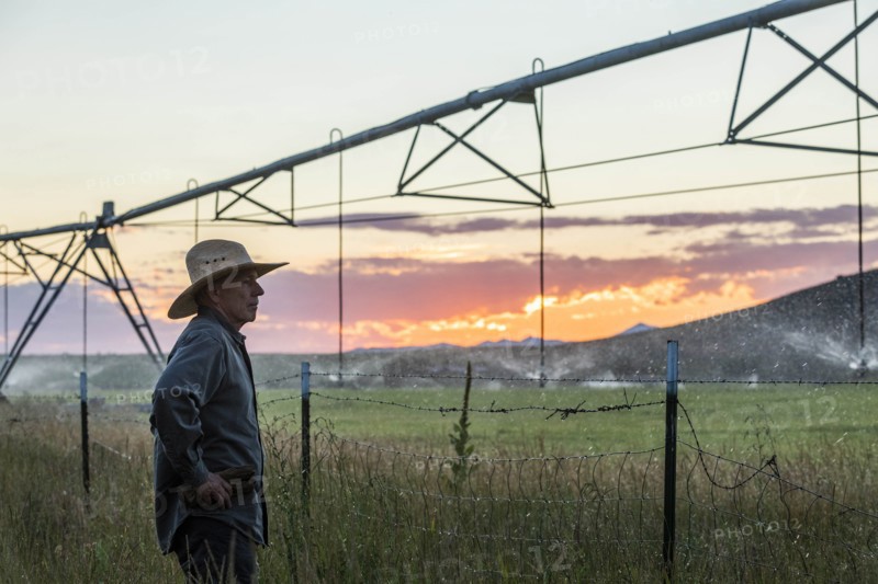 Farmer by irrigation at sunset in Picabo, Idaho, USA