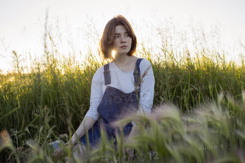 Young woman sitting in wheat field