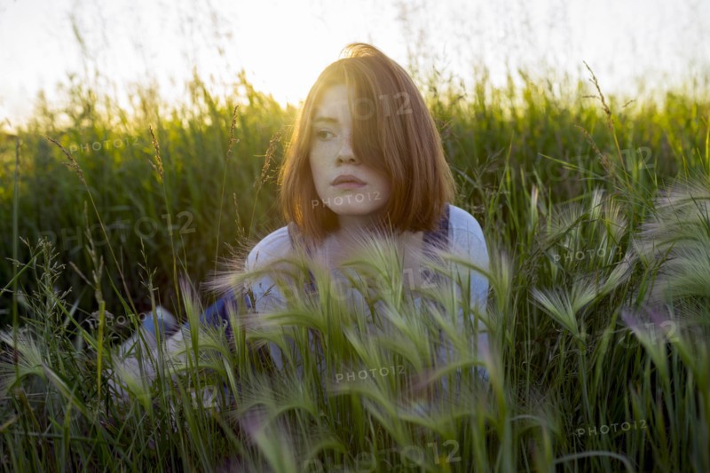 Young woman lying in wheat field