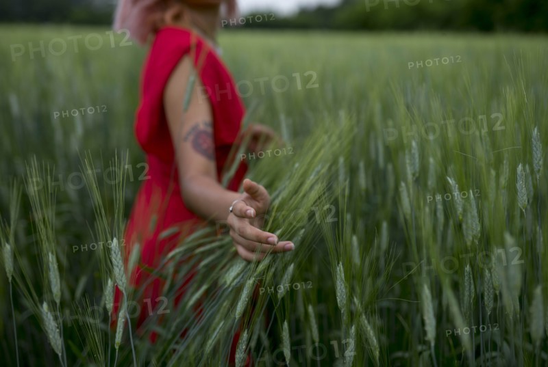 Woman wearing red dress in wheat field