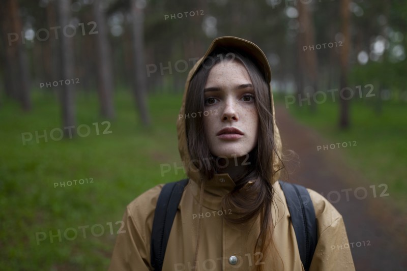 Portrait of young woman wearing brown raincoat