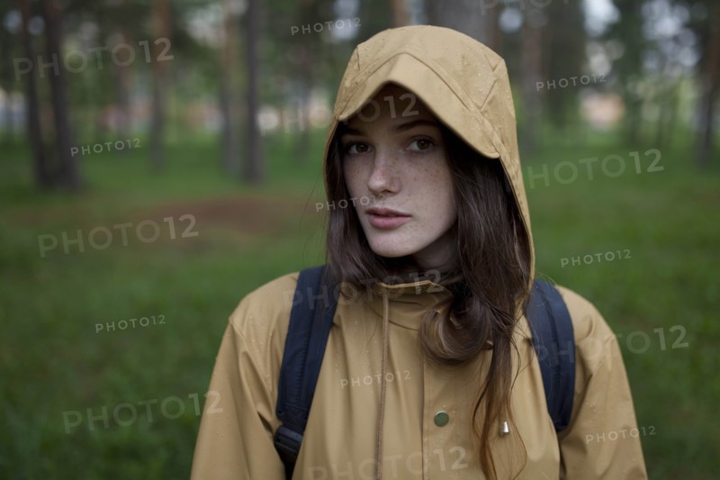Portrait of young woman wearing brown raincoat