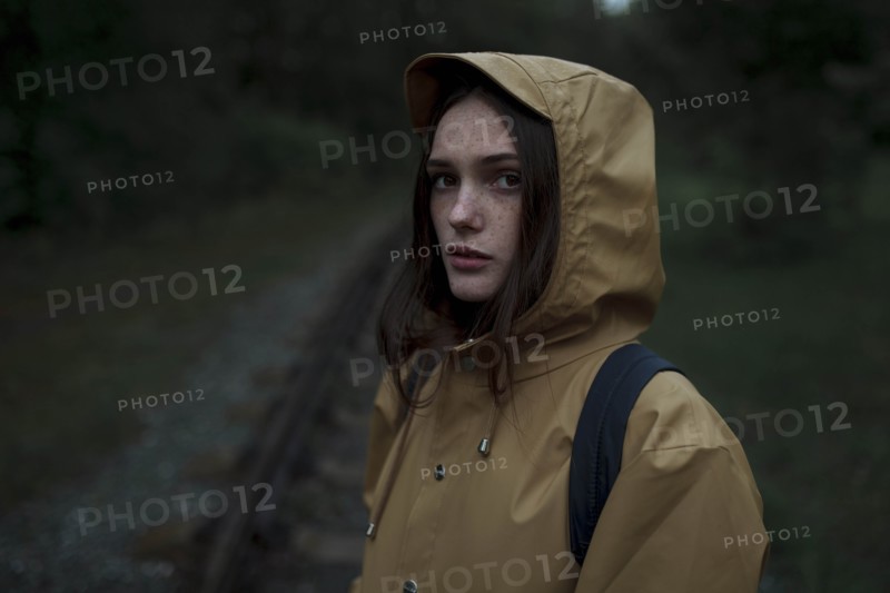 Young woman wearing brown raincoat