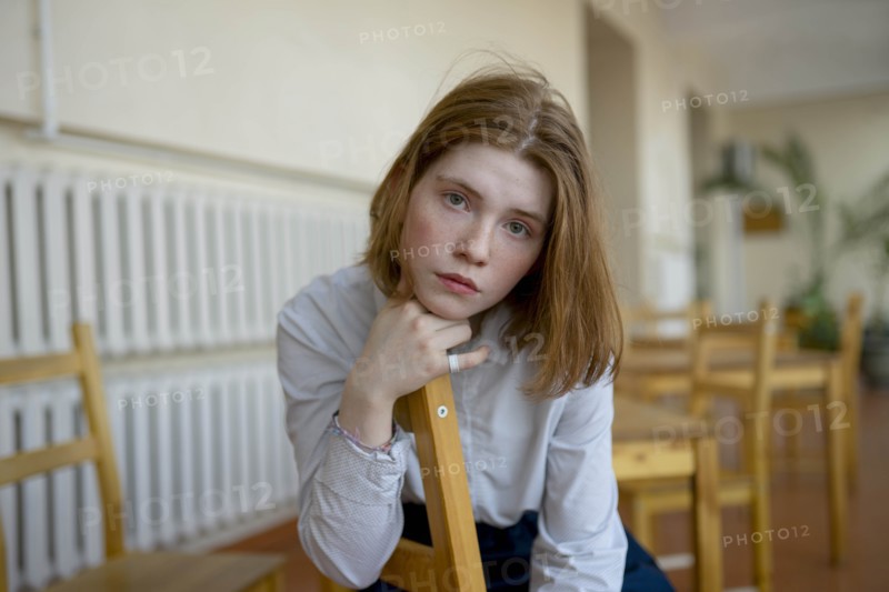 Young woman leaning on wooden chair