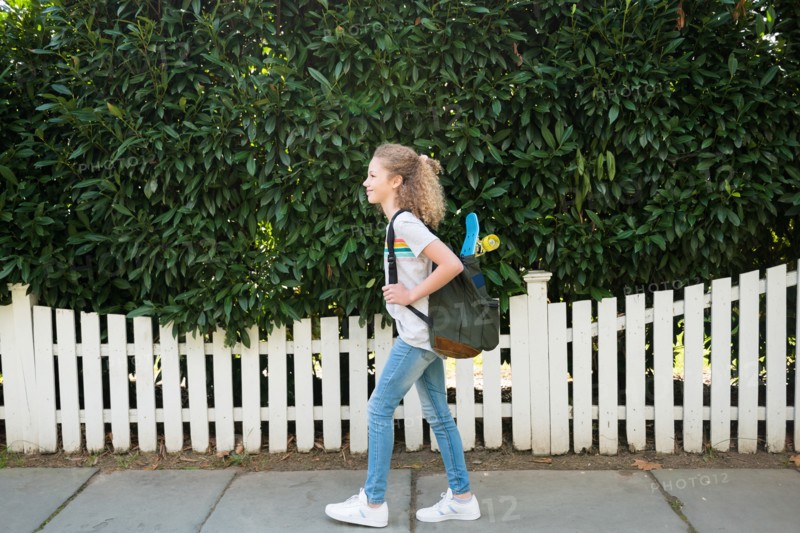 Girl with skateboard in backpack