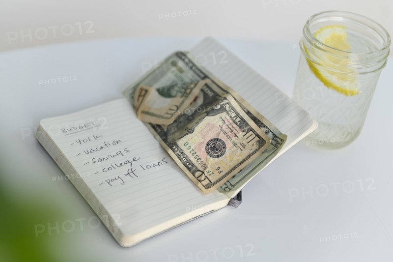 Budget list in notebook with money