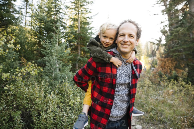 Father and son piggyback in forest