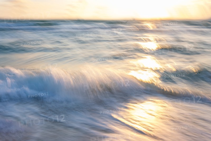 Blurred image of sun reflecting on waves