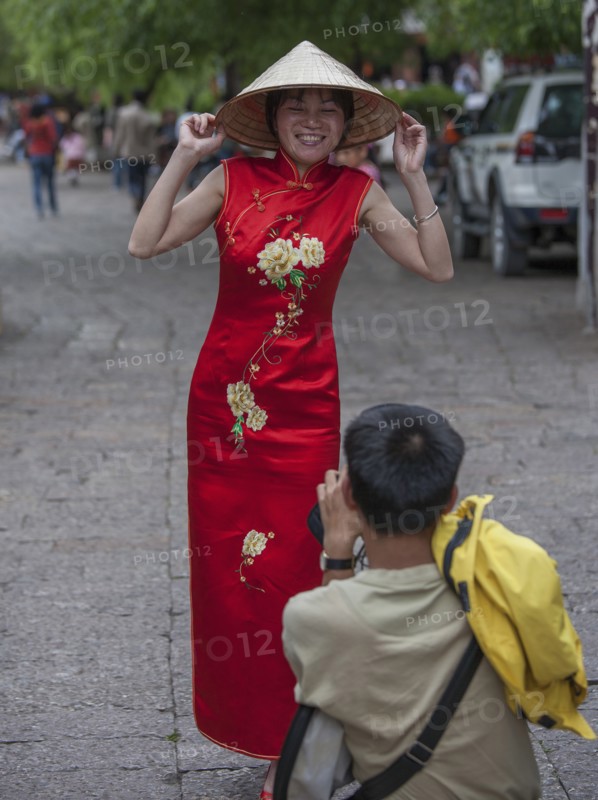 Man photographing woman wearing red dress in Lijang, Shangri-La Region, Yunnan Province, China