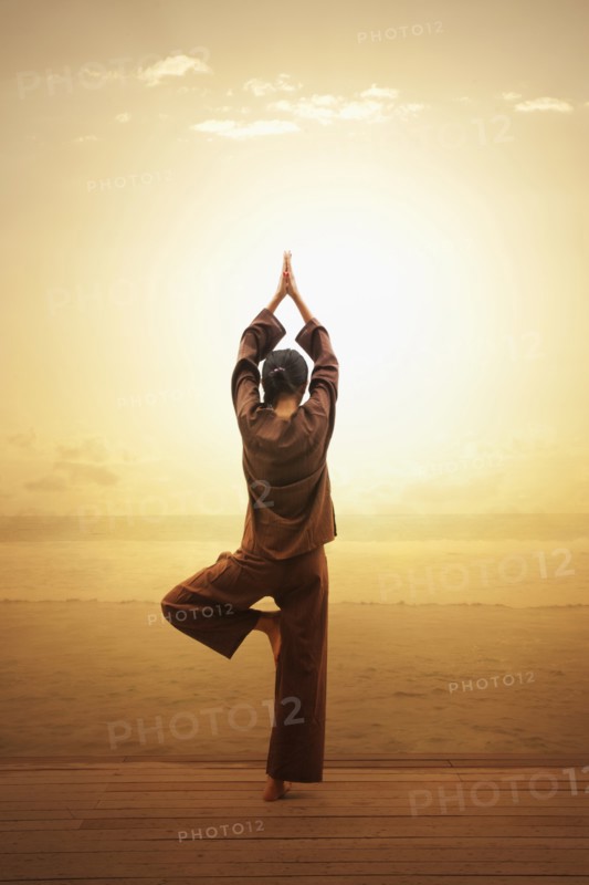 Woman doing yoga by beach in South Male Atoll, Maldives, South Asia