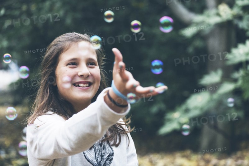 Smiling girl playing with bubbles