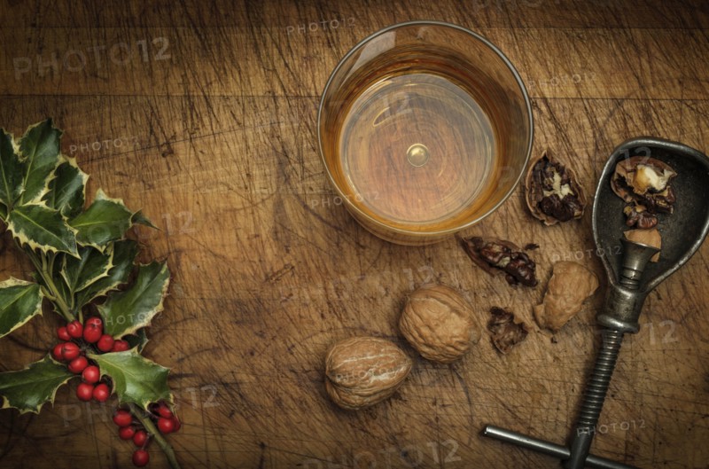 Mistletoe, drink in glass, walnuts and nut cracker