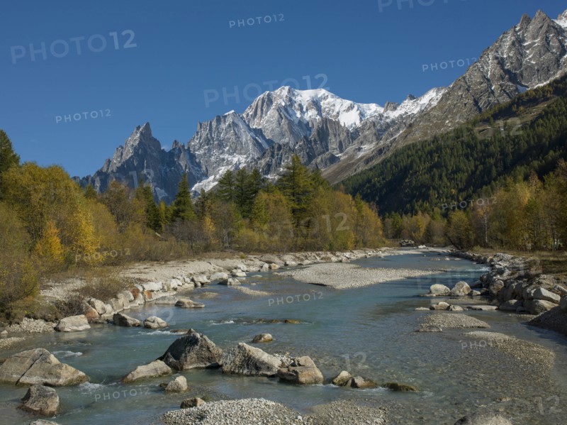 Snowcapped mountain by river in Aosta Valley, Italy