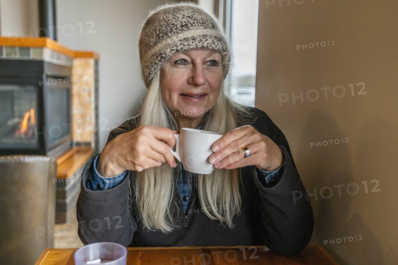 Woman wearing winter clothing holding cup