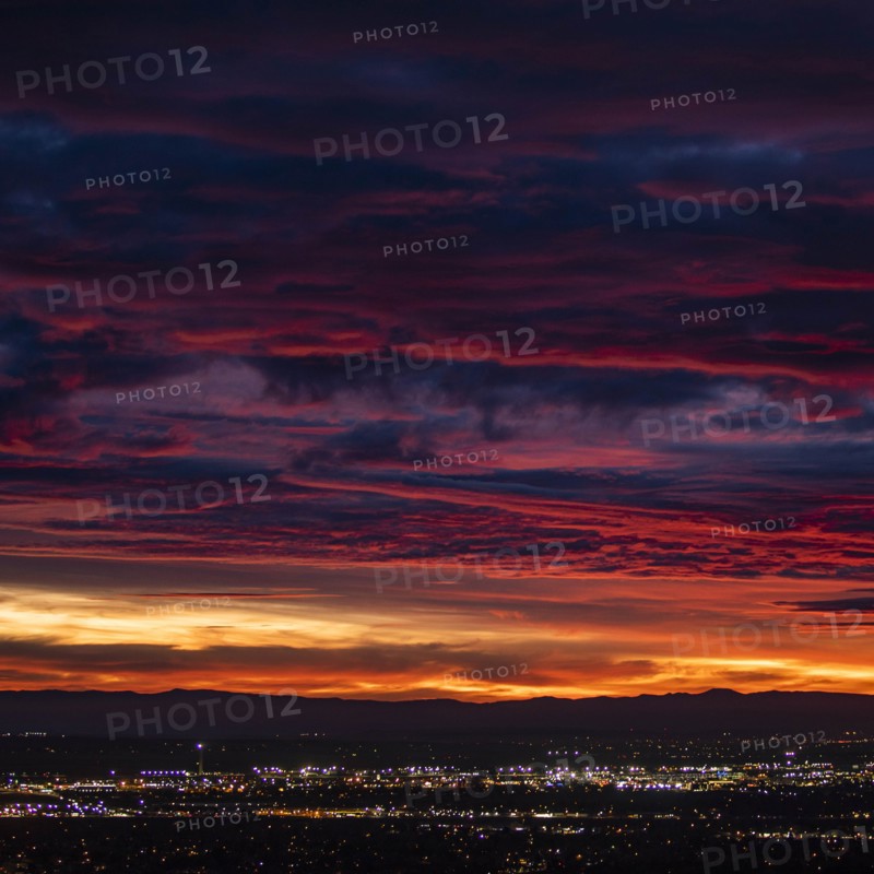 Cityscape under dramatic sky at sunset
