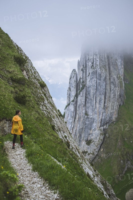 Woman wearing yellow jacket on mountain in Appenzell, Switzerland