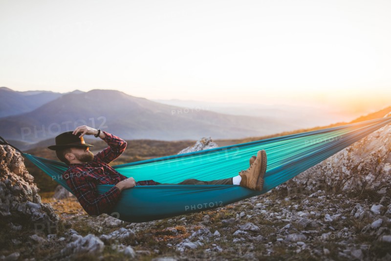 Man sleeping on hammock in mountain range