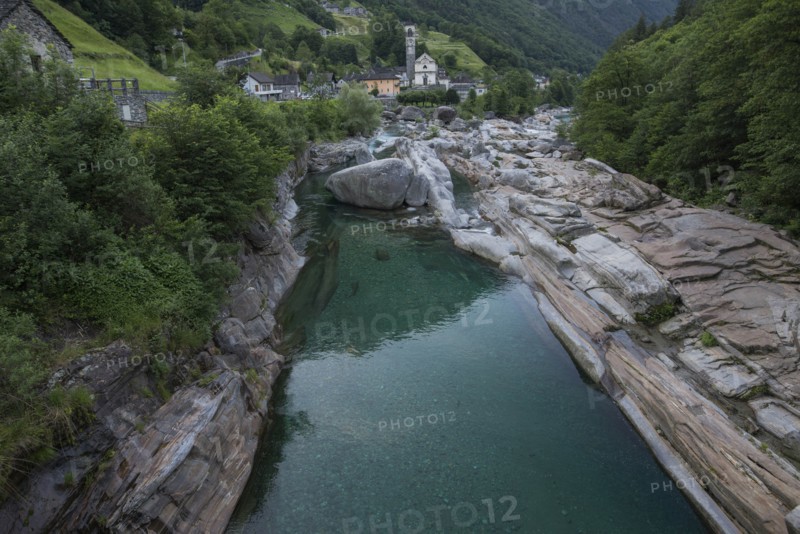 Bell tower by river in Ticino, Switzerland