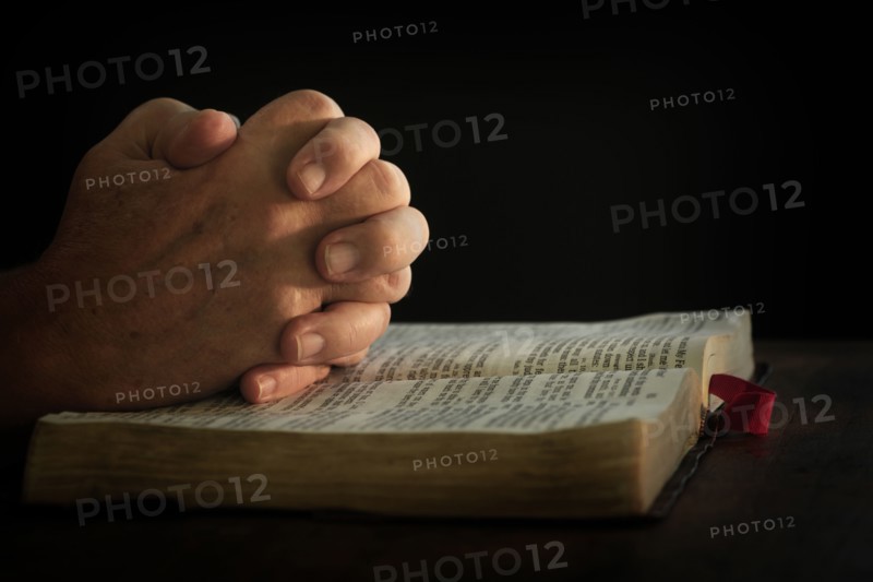 Man's hands on open bible