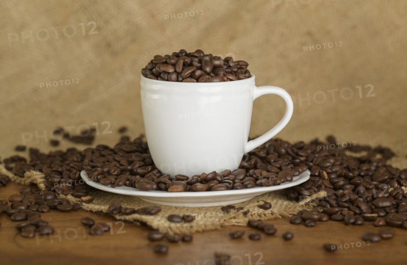 Coffee beans in cup and saucer