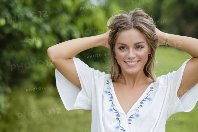 Smiling young woman with hands in her hair