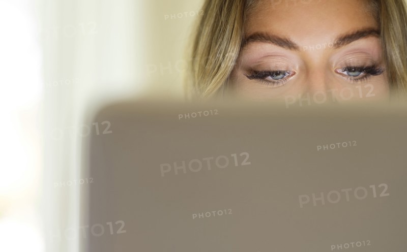 Eyes of young woman using laptop