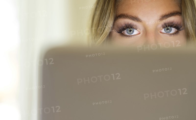 Eyes of young woman using laptop
