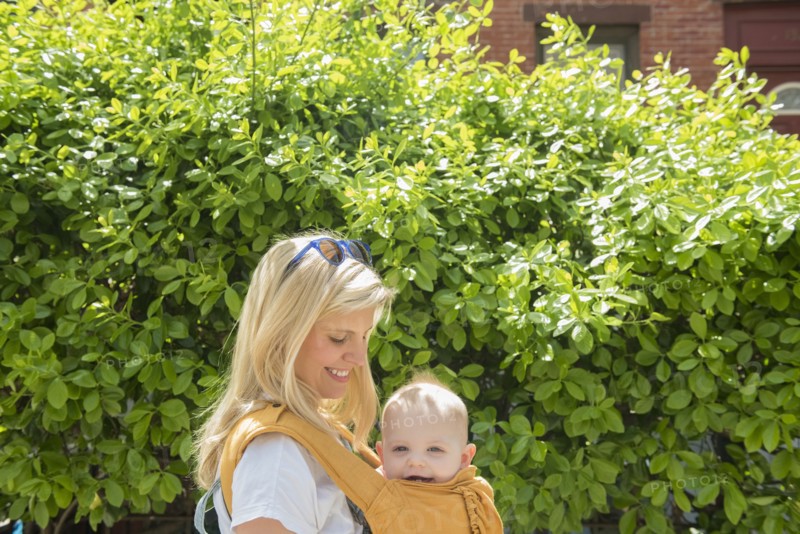 Mother carrying her daughter in baby carrier