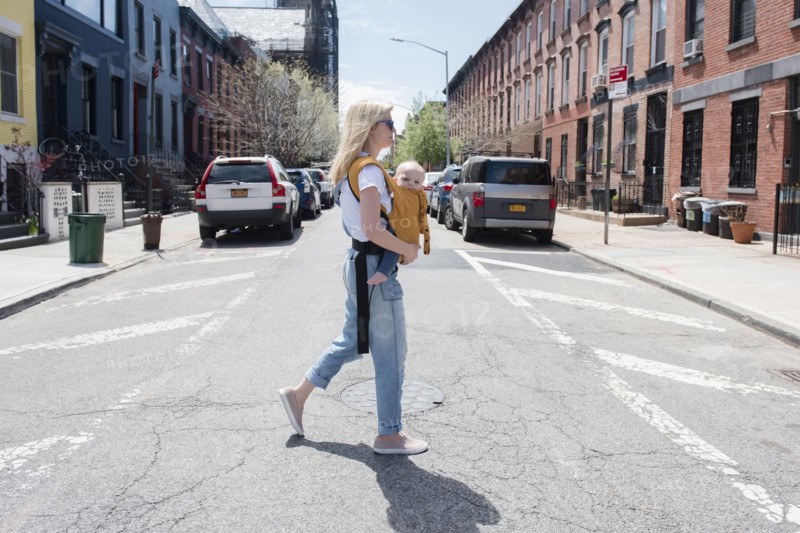 Mother carrying her daughter in baby carrier