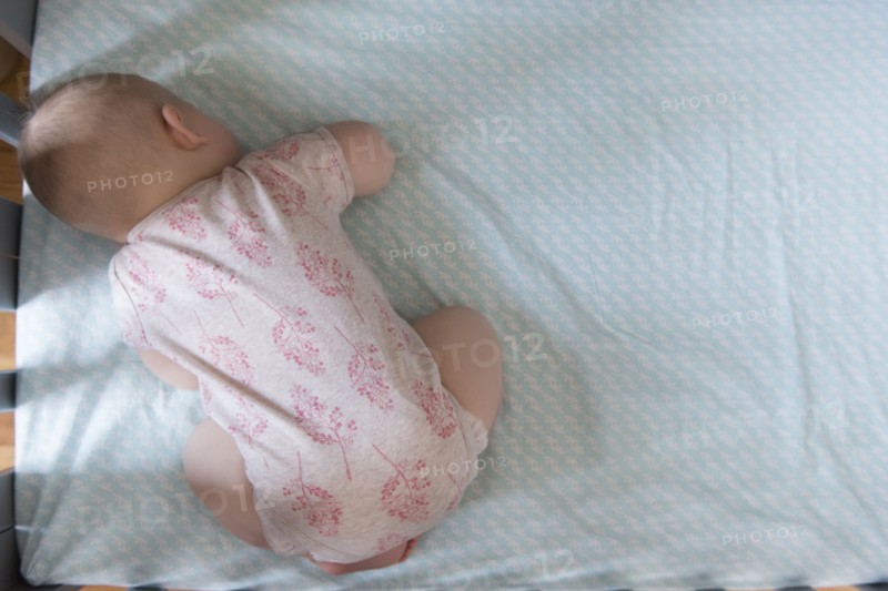 High angle view of baby sleeping in crib