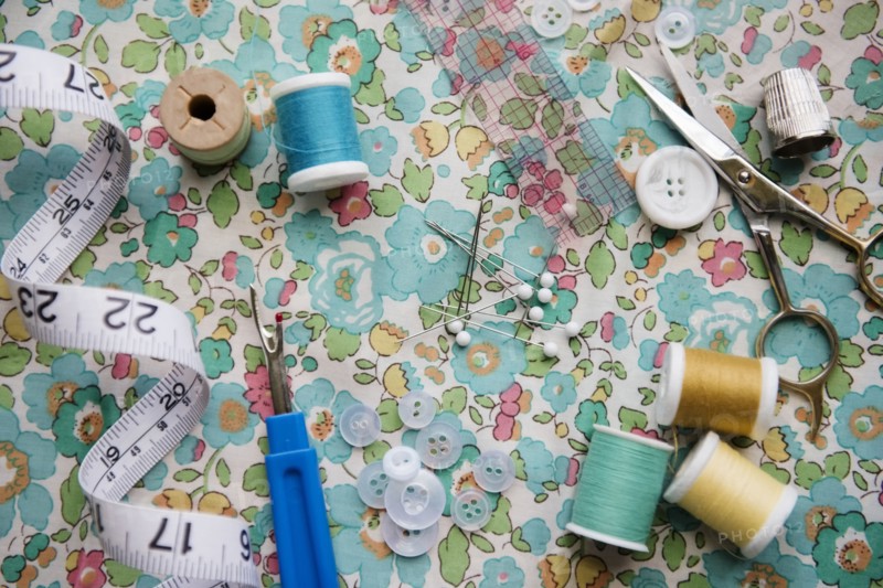 Spools of thread, seam ripper, and measuring tape