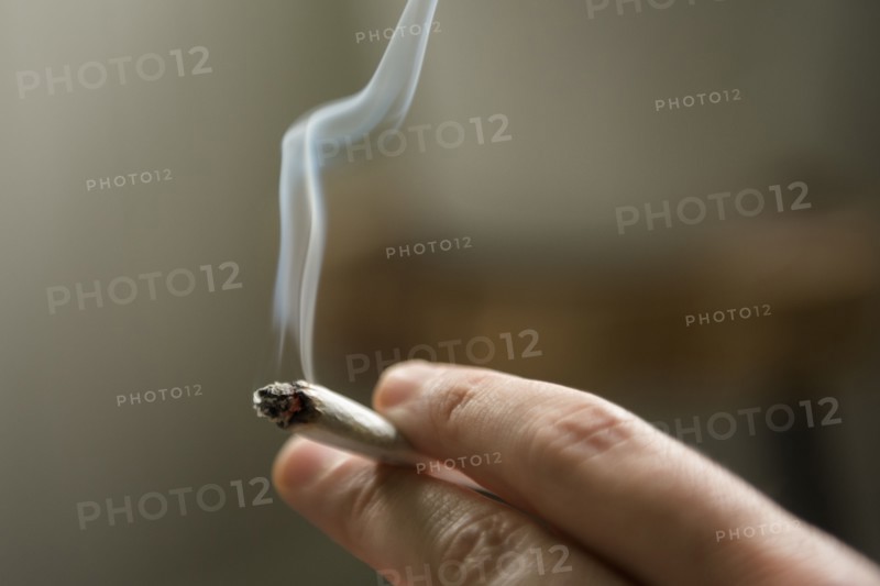 Hand of woman smoking marijuana joint