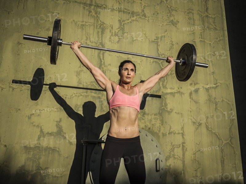 Woman weight lifting with barbell