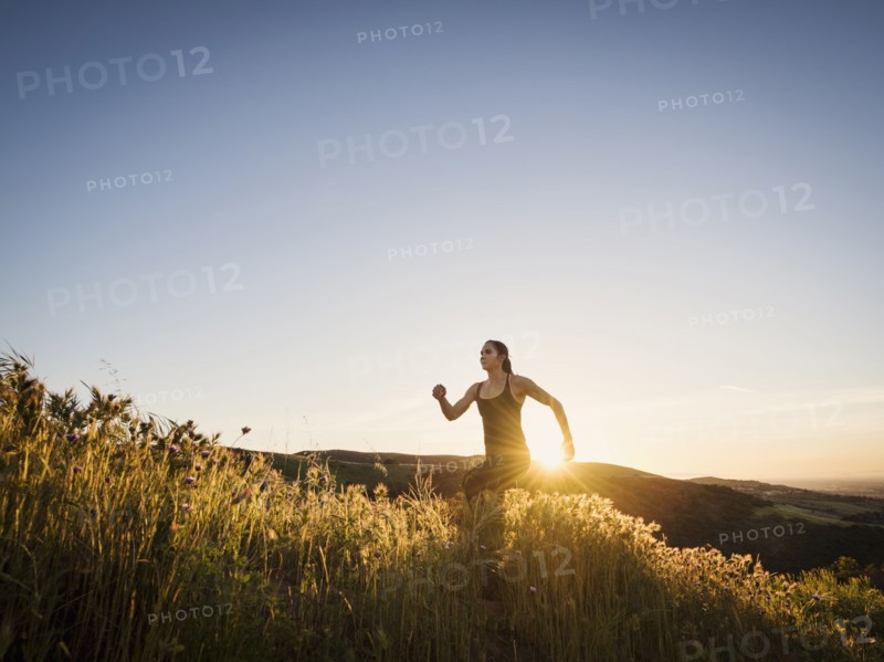 Mid adult woman jogging at sunset