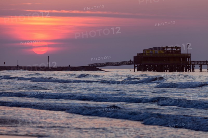 Beach and pier at sunset in Galveston, Texas