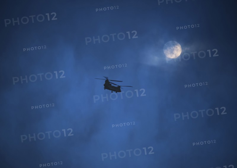 Military helicopter in night sky