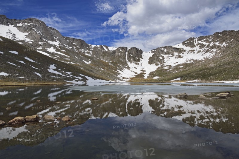 Snow on mountains by lake at Mount Evans Scenic Byway, Colorado