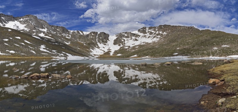Snow on mountains by lake at Mount Evans Scenic Byway, Colorado