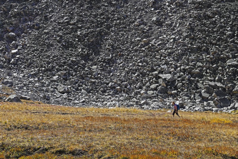 Woman hiking by talus slope in Mayflower Gulch, Colorado