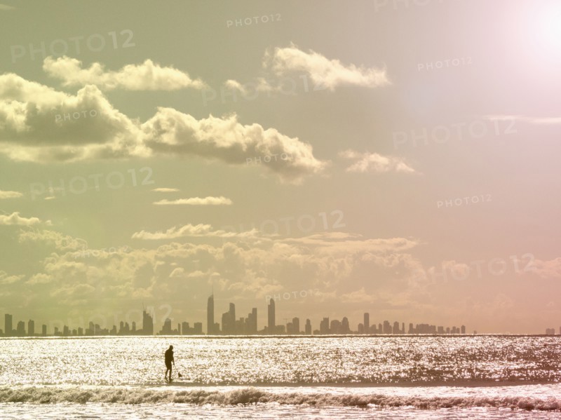 Silhouette of man paddleboarding on sea at sunset