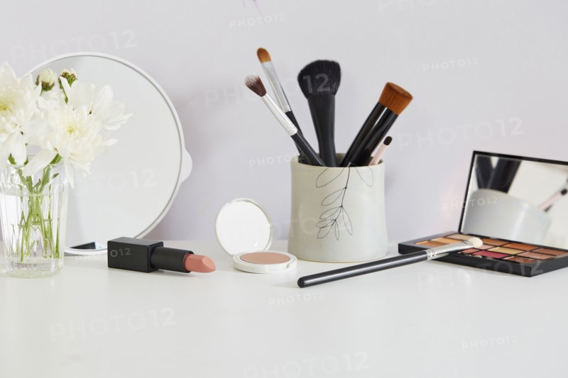 Flowers and make-up on white table