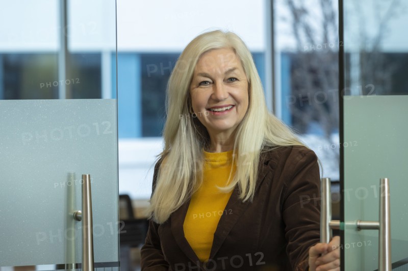 Smiling businessman opening door in office