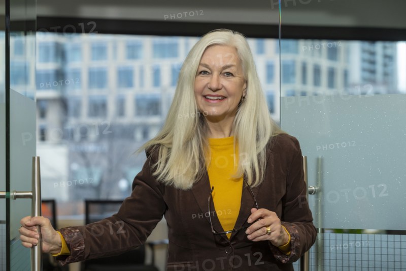 Smiling businessman opening door in office